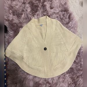Knit poncho sweater with pockets.